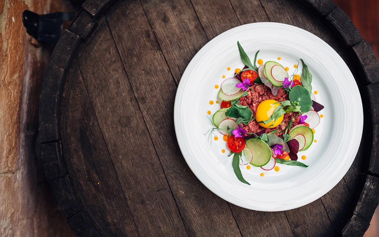 plate with fresh salad on a wooden barrel